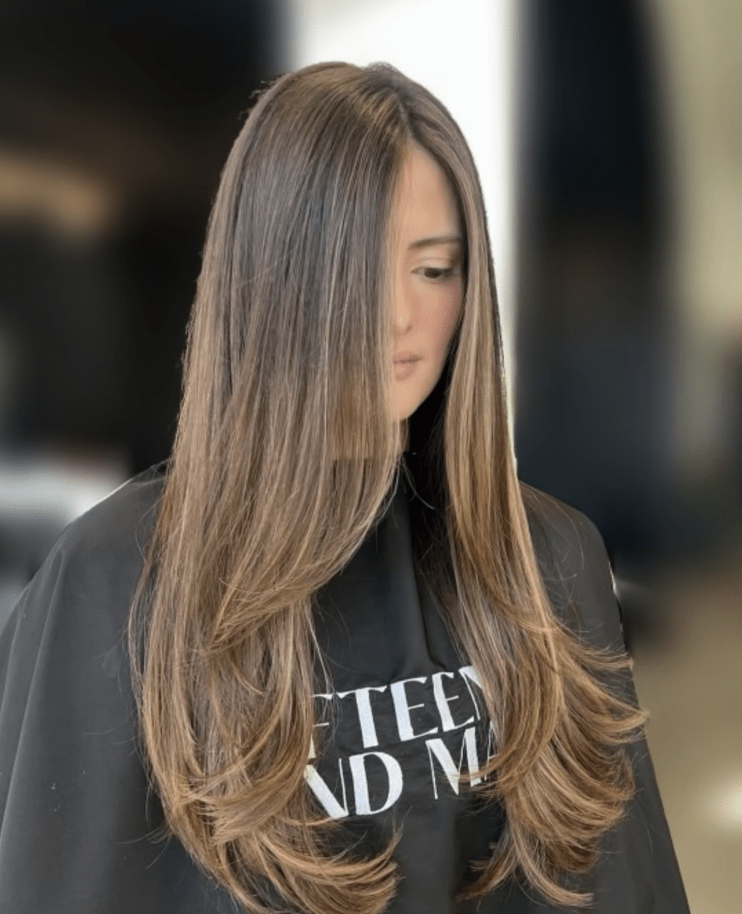 Warm brunette balayage swept to one side, hand painted at Studio One Six in Las Cruces
