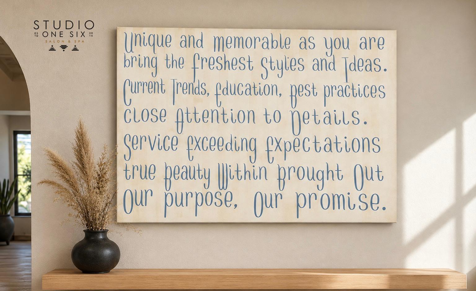 The Studio One Six promise, hand-lettered on canvas and hung in the salon's adobe gallery entry